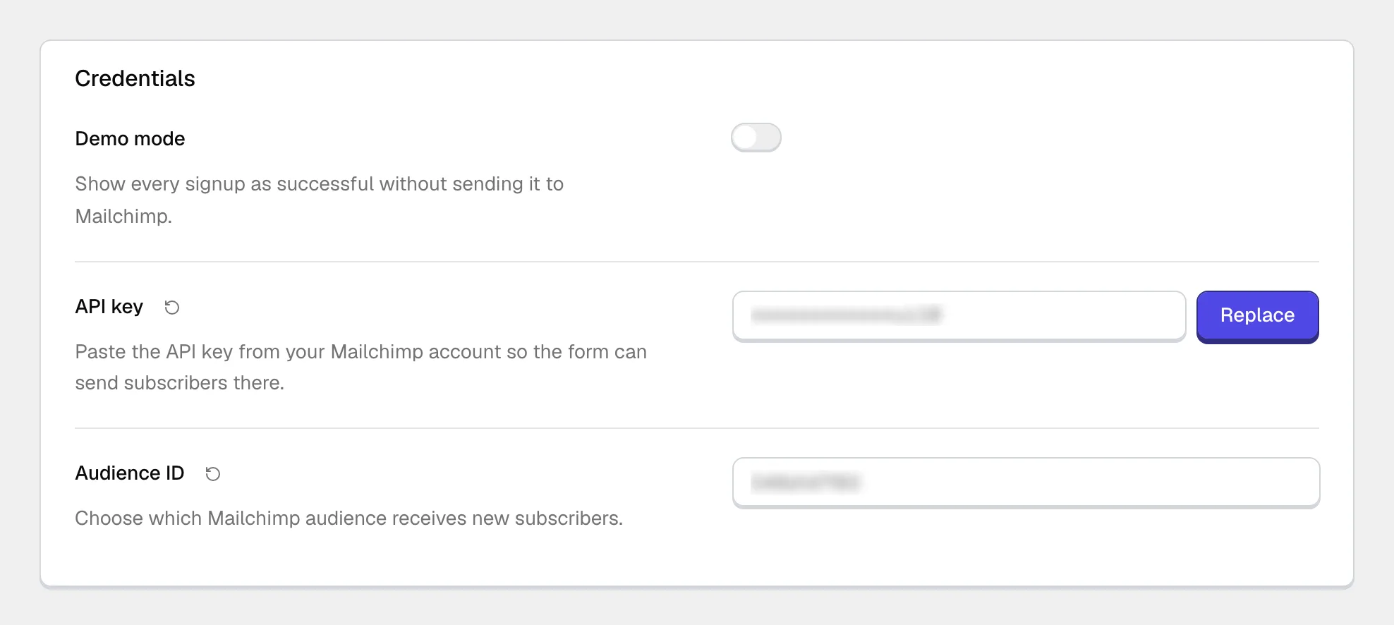 The Mailchimp Credentials group in Theme Options: a Demo mode toggle switched off, a saved API key shown masked with a Replace button, and an Audience ID field, both values blurred.